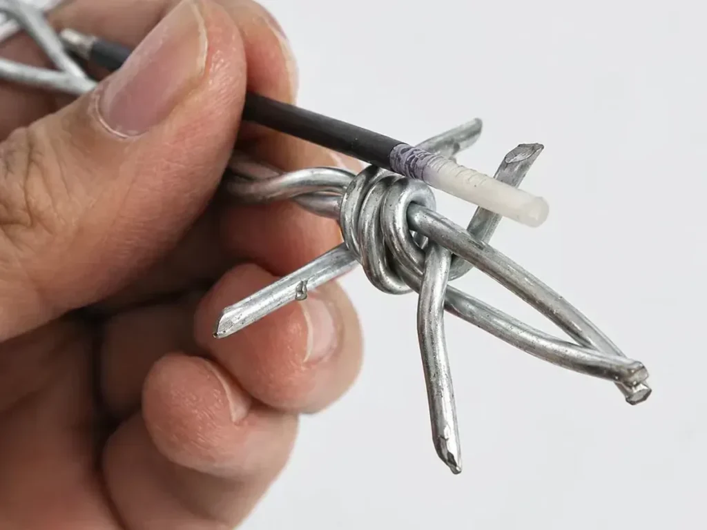 Close-up of a four-point barb wrapped around two twisted line wires