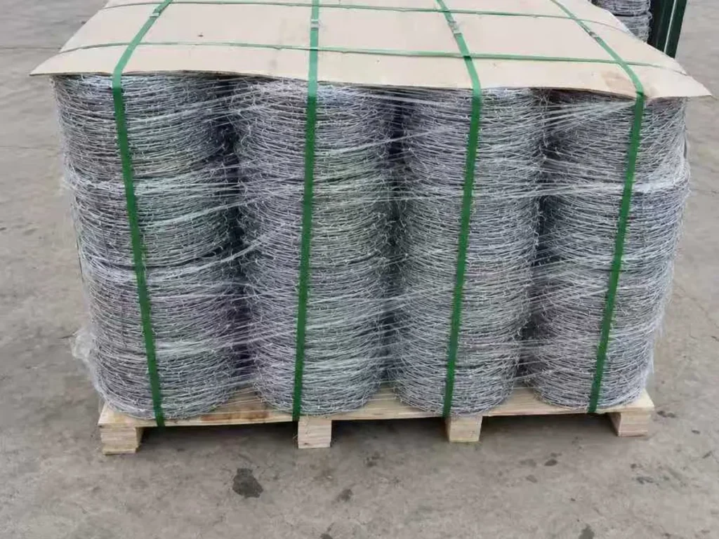 Barbed wire coils stretch-wrapped and strapped on a wooden pallet
