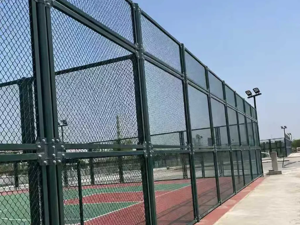 Green PVC-coated chain link fence around sports courts