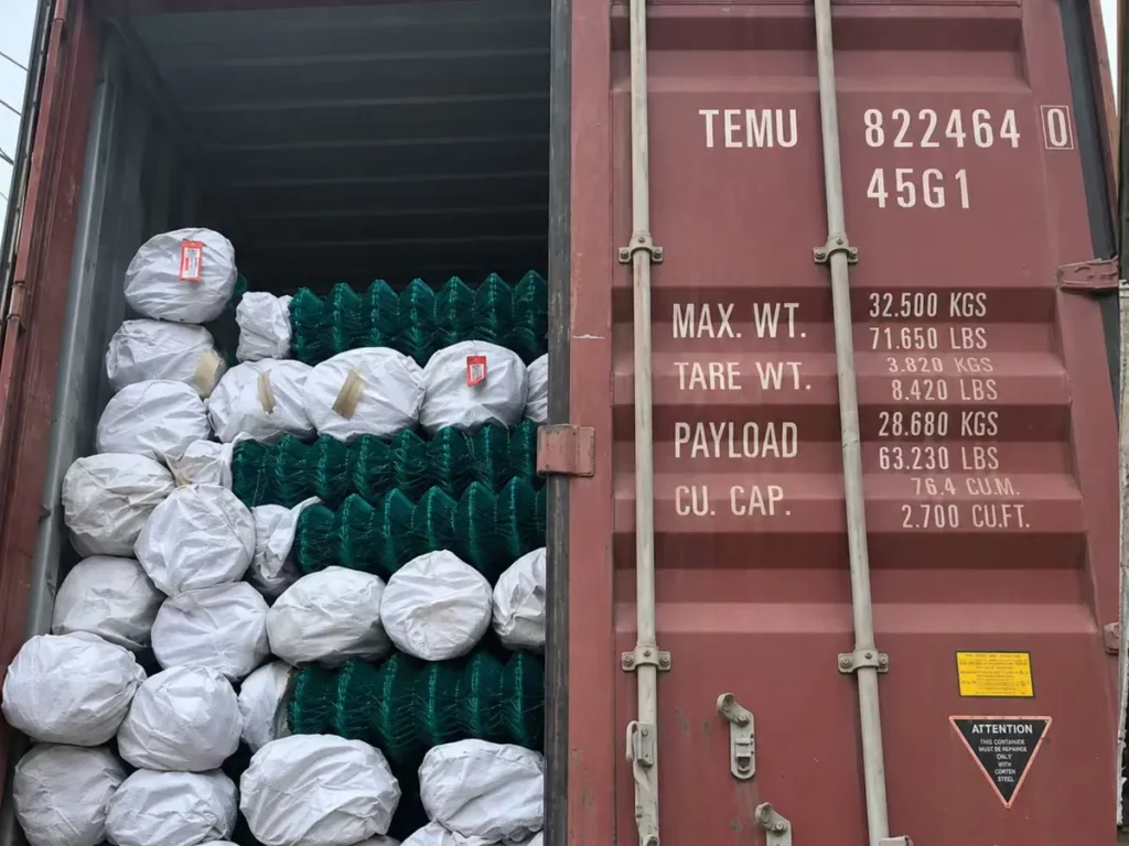 Chain link rolls wrapped in woven bags and loaded in a container