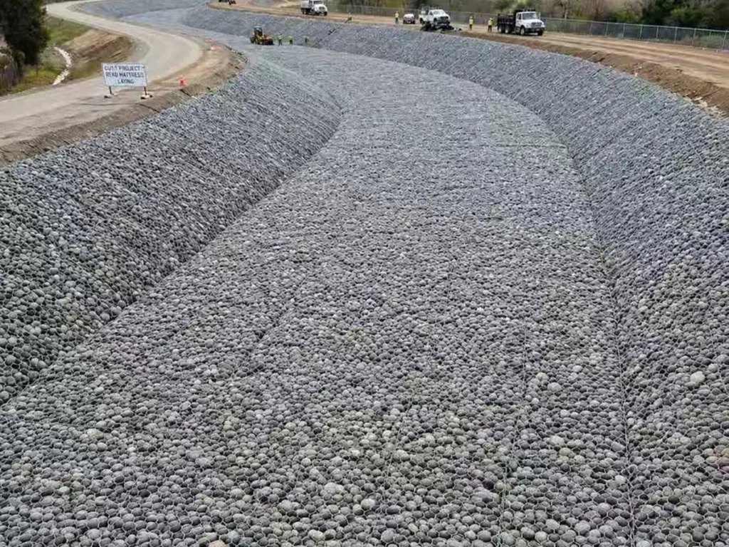 Stone-filled hexagonal mesh lining a river channel